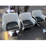 Three modern cream and black leather swivel armchairs