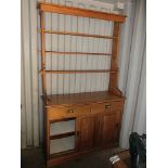 An early 20th century pine dresser with three shelves over two drawers and three sliding drawers, on