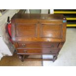 An early 20th century oak bureau, the fielded fall flap revealing fitted pigeonholes interior and