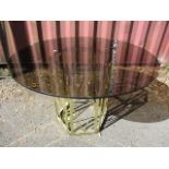 A circular glass topped dining table on a metal base, 28 h x 47 w