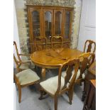 A modern yew wood, extending dining table 29 1/2 h x 55w (un-extended) with two leaves and eight