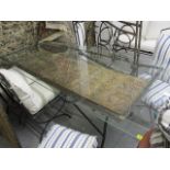 A large modern, wrought iron and glass topped dining table with door beneath the glass, 31 1/2h x 91