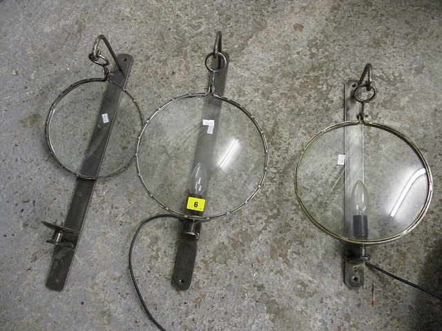 A set of three modern wrought steel wall lights, one without light fitting