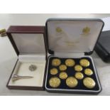 A boxed set of twelve Firmin & Sons buttons, together with a silver golf tee and lapel badge