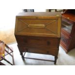 An early 20th century oak bureau, together with a mahogany-finished mirrored back overmantle mirror