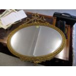A late Victorian gilt gesso mirror of oval form with garland decoration, 34 x 35