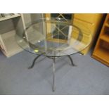 A wrought iron, glass topped table on four splayed legs, 30h, 39.5 dia