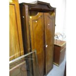 A 1930s walnut and mahogany wardrobe with twin panelled doors, raised on stubby cabriole feet, 73