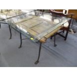 A wrought iron, glass topped dining table with ornate carved door, 31h, 39.5w, 39 d