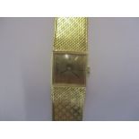 A ladies 18ct gold Omega bracelet watch. The signed, square gilt dial with baton numerals and