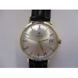 A gents 1960s 9ct gold Zodiac manual wind date wristwatch. The signed, brushed, silvered dial with