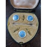 A set of three silver and enamelled stud buttons, boxed