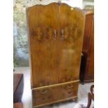 An early 20th century walnut wardrobe having twin doors over two drawers, 75 h, 35 w, 21 d