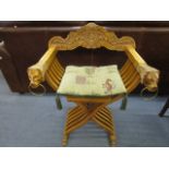 A light wood x framed folding campaign chair with lion head and ring arm terminal, lion paw feet and