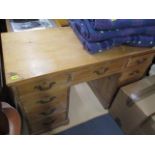 A late Victorian pine, twin pedestal desk having central drawer, flanked by eight short drawers,