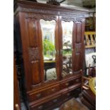 A Victorian mahogany wardrobe with carved, floral decoration, having four drawers below a pair of