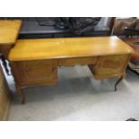 A modern light oak French desk having a single drawer between two cupboards, 27 1/2 h x 53 1/2 w