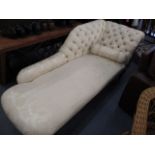 An Edwardian mahogany and cream, floral upholstered chaise longue, with a button back, and bolster