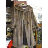 A mink three quarter length coat in brown with central fur bobble style button