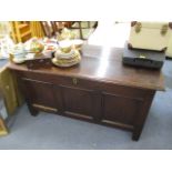 An early 18th century oak chest having a hinged top over a tripanelled front, raised on reduced