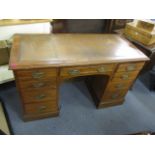 A late Victorian mahogany, leather topped desk having one long drawer and eight short drawers, 29