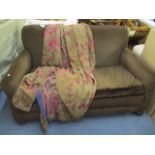 An Archibald Kenrick & Sons, two seater sofa in brown dralon, with loose covers having front oak