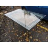 A modern wrought steel, glass topped dining table having an antique door beneath the glass, 30 1/2