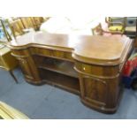 A Victorian mahogany cushion moulded sideboard having two central shelves flanked by cupboards and