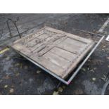 A large modern wrought steel, glass topped coffee table having an antique door beneath the glass, 17