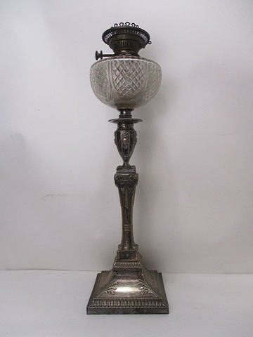 A late Victorian silver plated oil lamp having a clear glass reservoir with line cut decoration,