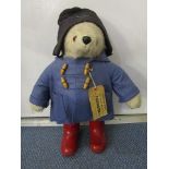 A Gabrielle Design Ltd Paddington bear, wearing a blue duffel coat, red wellington boots and luggage