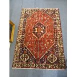 A Persian Shiraz rug having a red ground and geometric designs, 64 1/2 x 43 3/4