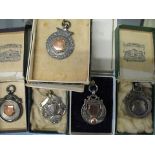 A group of five early 20th century silver sporting watch fobs, medals for football and gymnastics