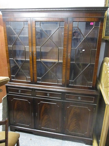 A reproduction mahogany side cabinet, the dentil moulded cornice over three astragal glazed
