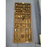 A wooden display tray with pewter, copper and brass ornament