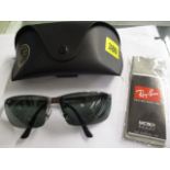 A pair of Ray Ban sunglasses with black arms stamped RB3276 004/71 6413 3N, in a soft case