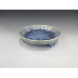 A Ruskin shallow Bowl with blue drip glaze on three moulded shaped supports, 9 1/2in diam
