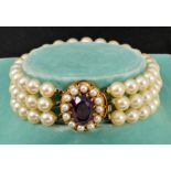 A Cultured Pearl triple strand Bracelet on clasp claw-set oval-cut amethyst within a frame of