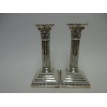 A pair of Edward VII silver Candlesticks with fluted columns, Corinthian capitals on stepped