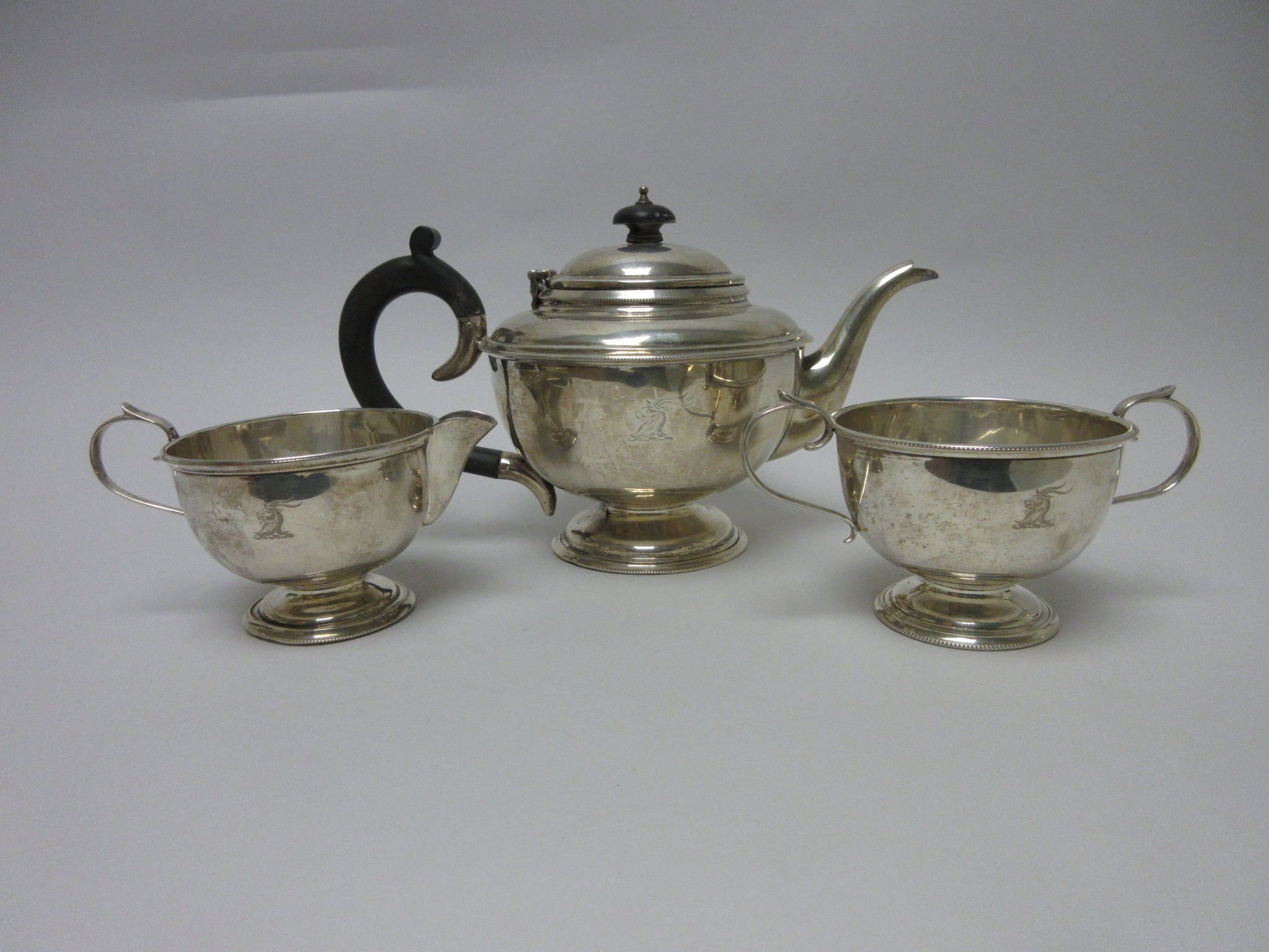 A George V silver plain circular three piece Tea Sevice engraved crest, Birmingham 1931 - Image 2 of 2