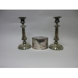 A plated oval Biscuit Box engraved crest and a pair of Candlesticks with leafage scrolls on circular