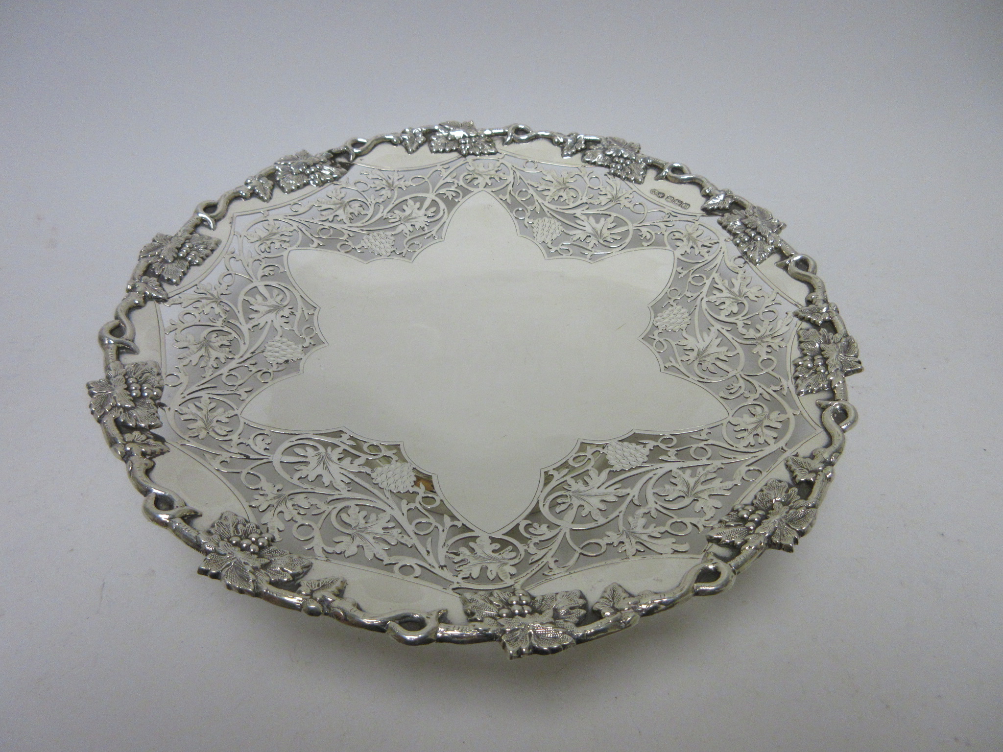 A Victorian circular Salver with scroll and rosette engraving, pierced floral swag and beaded border