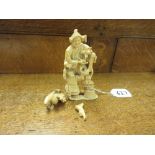 A Japanese ivory Okimono of a FarmerMeiji PeriodStanding holding a pipe surrounded by monkeys and