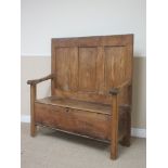 An antique elm Settle with three panel back, hinged box seat and shaped arms, 3ft 11in