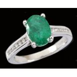 An Emerald and Diamond Ring claw-set oval-cut emerald, 1.70cts, between rows of channel-set
