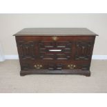 An antique oak Mule Chest with hinged top, panelled front above two panelled drawers on bracket