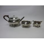 A George V silver Arts and Crafts three piece Tea Service of circular form with hammered design on