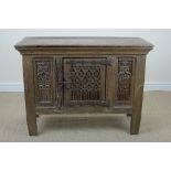 An antique oak Cupboard with single carved panelled door flanked by carved panels on squared