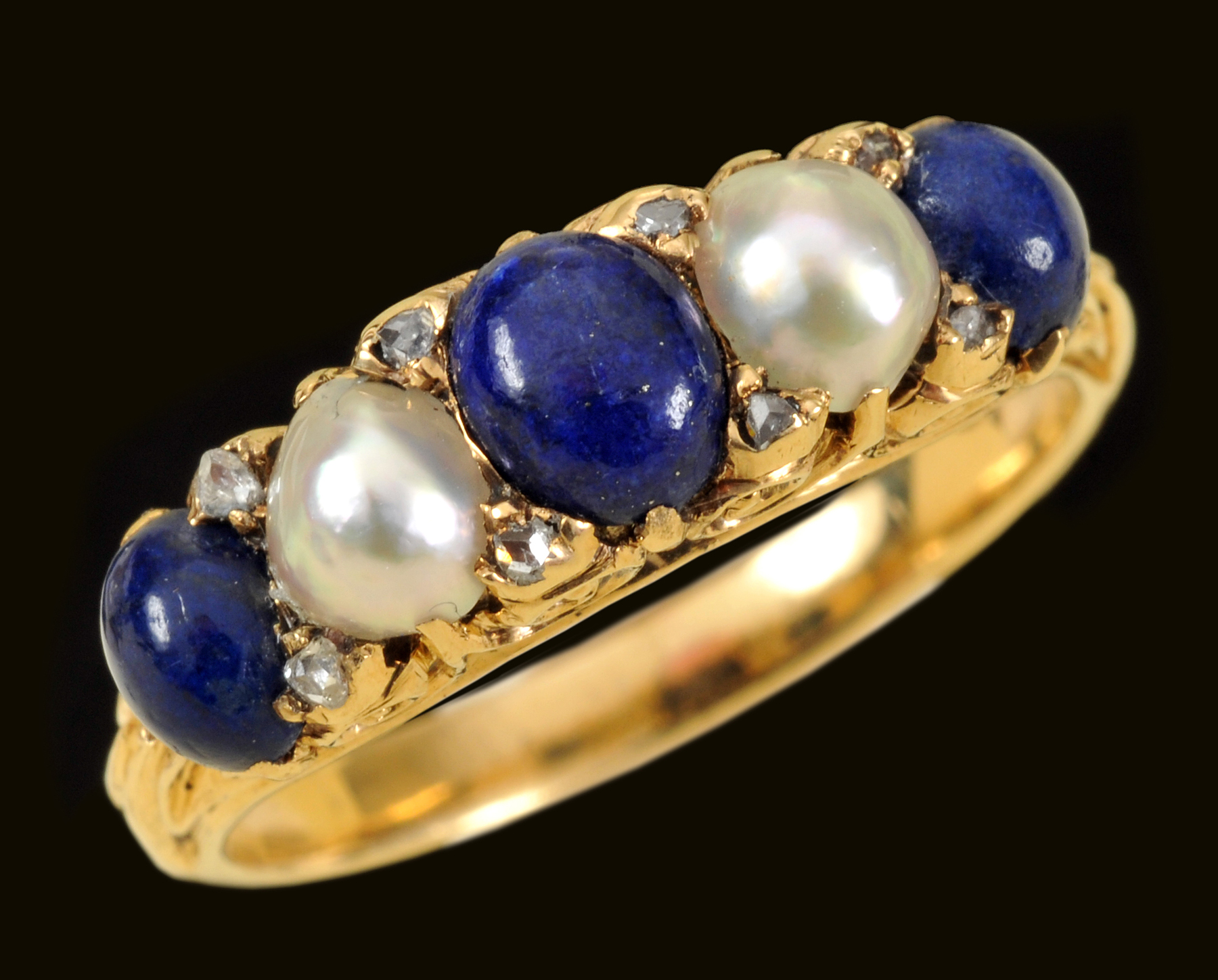 A Lapis Lazuli and half Pearl Ring claw-set three graduated lapis cabochons interspersed with two