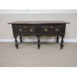 An 18th Century oak Dresser Base fitted two drawers above shaped frieze on baluster turned and